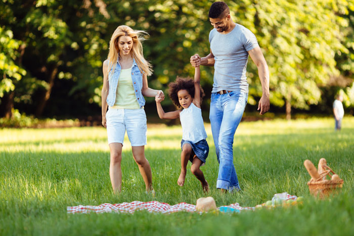 6 Ideas for Sober Family Fun - mom and dad holding hands with daughter at picnic