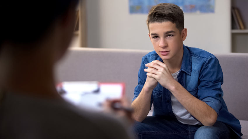 teenage boy talking to his therapist - young adult drug rehab center - teen drug rehab
