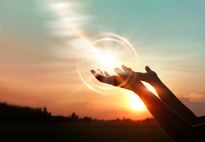 Religion and Addiction, Spirituality, closeup of person's hands being held up to the sky during sunrise - spirituality in recovery