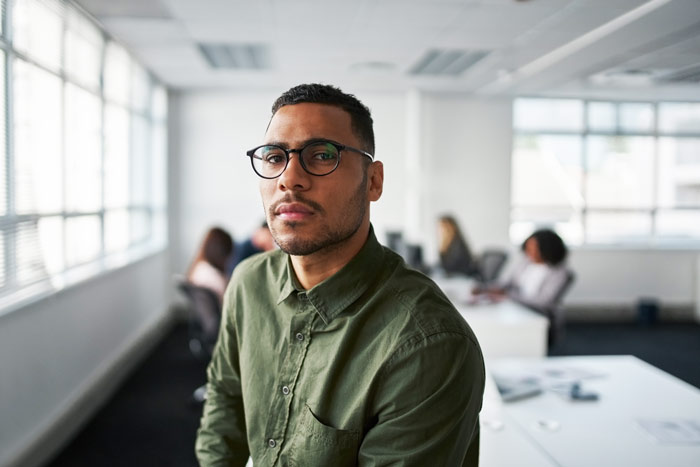 handsome serious looking young Black man at work in office - high-functioning
