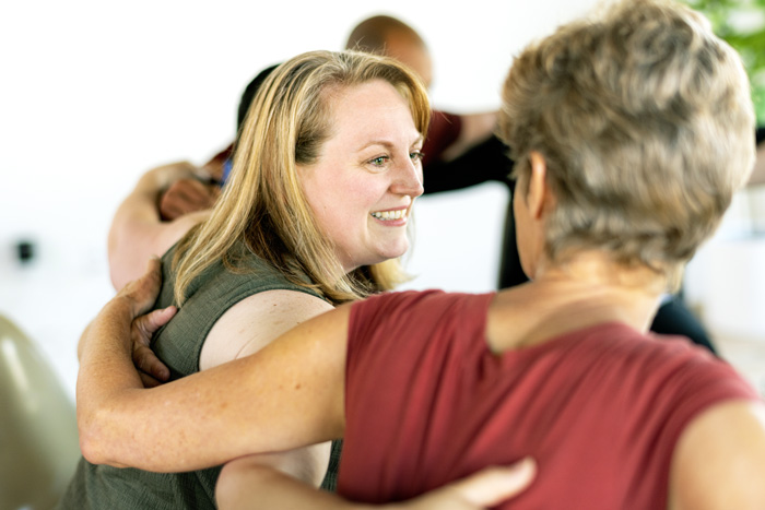 Affordable Outpatient Rehab Program in Statesboro, Adult Outpatient, group of adults in therapy session or support group - two women with arms around each others' shoulders -